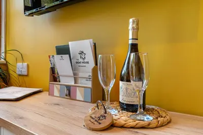 a bottle of wine and two glasses on a table at Romantic, secluded cottage in Cardinham Woods, Cornwall in Cardinham