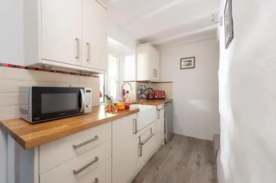 a kitchen with white cabinets and a microwave at 2 Bedroom Home in Marazion, views of St Michael's Mount in Marazion