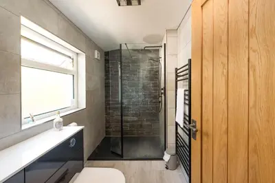 a bathroom with a shower and a toilet and a window at 2 Bedroom Home in Marazion, views of St Michael's Mount in Marazion