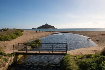 a bridge over a body of water on a beach at 2 Bedroom Home in Marazion, views of St Michael's Mount in Marazion