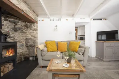 a living room with a couch and a fireplace at 2 Bedroom Home in Marazion, views of St Michael's Mount in Marazion
