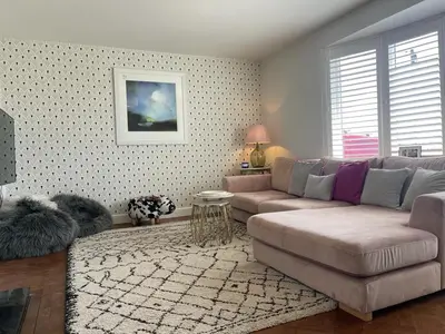 a living room with a couch and a table at Baywatch Mawgan Porth Spacious Home sleeps 9, Games room, Parking & Garden in Mawgan Porth