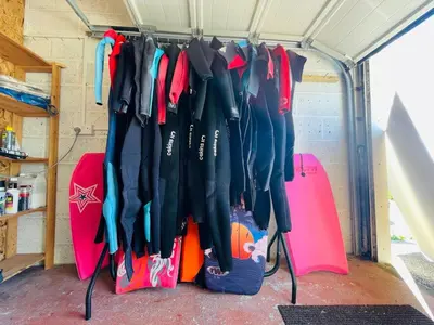 a group of umbrellas hanging in a garage at Baywatch Mawgan Porth Spacious Home sleeps 9, Games room, Parking & Garden in Mawgan Porth