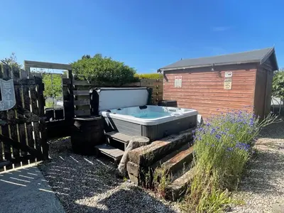 a hot tub sitting next to a building at Baywatch Mawgan Porth Spacious Home sleeps 9, Games room, Parking & Garden in Mawgan Porth