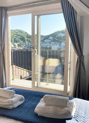 a bedroom with a bed and a large window at Looe with a View - Entire apartment with FREE allocated parking in Looe
