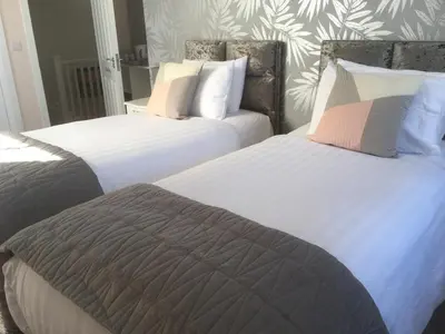 two beds sitting next to each other in a bedroom at Loggans Lodge in Hayle
