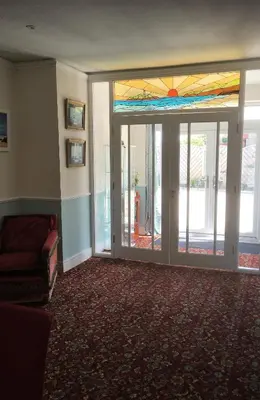 a living room with a stained glass window and a couch at Loggans Lodge in Hayle