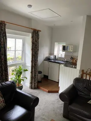 a living room with a couch and a kitchen at The Granary at Bissick Old Mill in Truro