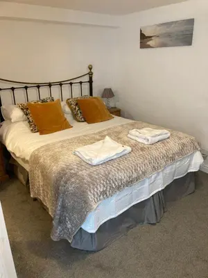 a bedroom with a bed with two towels on it at The Granary at Bissick Old Mill in Truro