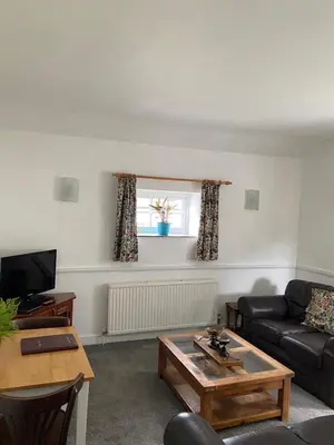 a living room with a couch and a table at The Granary at Bissick Old Mill in Truro