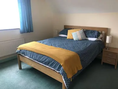 a bedroom with a large bed with a wooden headboard at Detached House 2 Bed Sleeps 4 Parking in Fowey