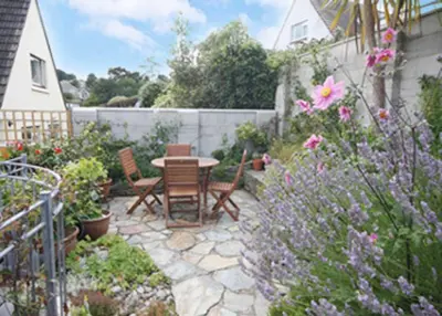a patio with a table and chairs and flowers at Detached House 2 Bed Sleeps 4 Parking in Fowey