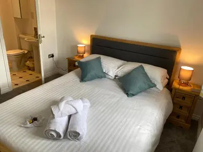 a bedroom with a bed with towels on it at Stylish 3 bed home with allocated parking for 2 in Liskeard