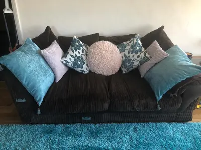 a couch with pillows on it on a blue rug at West Winds, Fore Street, Polruan by Fowey in Polruan