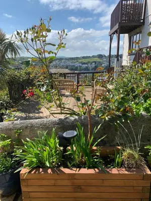 a garden with a bench and some plants at West Winds, Fore Street, Polruan by Fowey in Polruan