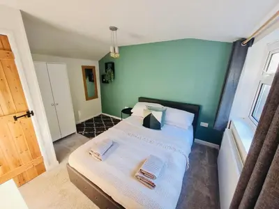a bedroom with a bed with two towels on it at The Annexe at Tenniside in Perranporth