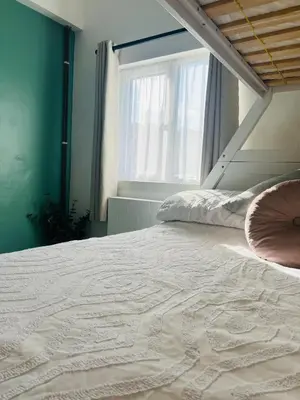 a bedroom with a large bed with a window at The Annexe at Tenniside in Perranporth