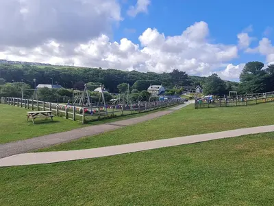 a park with a bench and a playground at The Annexe at Tenniside in Perranporth