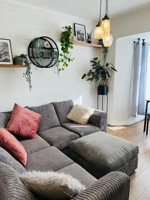 a living room with a gray couch with red pillows at The Annexe at Tenniside in Perranporth