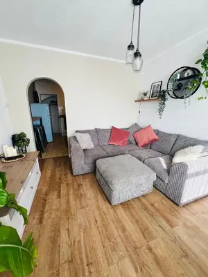 a living room with a gray couch and red pillows at The Annexe at Tenniside in Perranporth