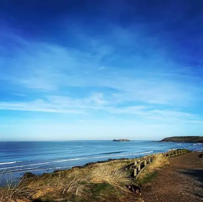 a view of the ocean from a beach with a wooden fence at Gold 10 - Cornish Coastal Retreats in Saint Hilary