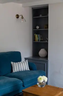 a blue couch in a living room with a book shelf at Charlestown cottage, Woodburner, Gardens & Parking in Charlestown