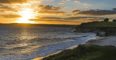 a sunset over the ocean with the sun setting at Charlestown cottage, Woodburner, Gardens & Parking in Charlestown