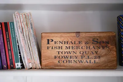 a wooden sign on a shelf with books at Finest Retreats - Primrose Cottage in Tywardreath