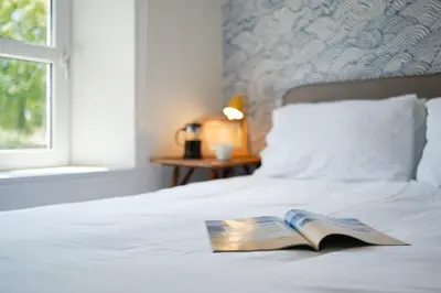 a book sitting on top of a bed at Finest Retreats - Primrose Cottage in Tywardreath