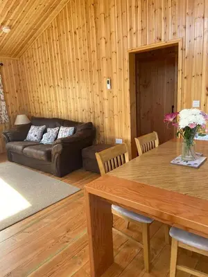a living room with a table and a couch at Rural Wood Cabin - less than 3 miles from St Ives in Penzance