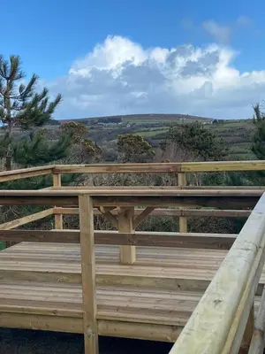 a wooden bench sitting on top of a wooden bridge at Rural Wood Cabin - less than 3 miles from St Ives in Penzance