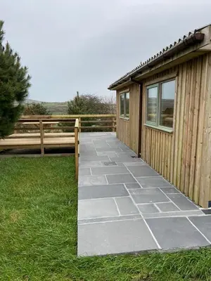 a walkway next to a building with a fence at Rural Wood Cabin - less than 3 miles from St Ives in Penzance