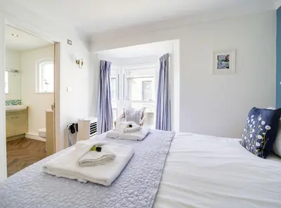 a bedroom with a bed with towels on it at The Artist Loft, Ensuite Guest Rooms, Porthleven in Porthleven