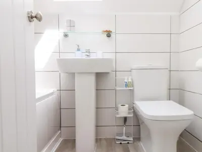 a white bathroom with a sink and a toilet at Penpoll in Wadebridge