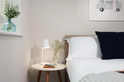 a bedroom with a bed and a table with a lamp at Tralee in Portreath