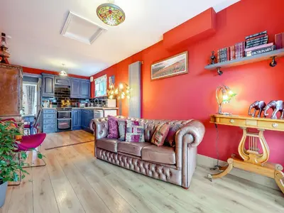 a living room with a couch and a red wall at Hindscarth Apartment - Uk39610 in Davidstow