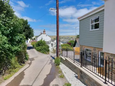an empty street with a house and a fence at Two bedroom cottage - country lane -10 min walk to Perranporth beach in Perranporth