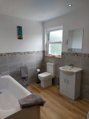 a bathroom with a tub and a sink and a toilet at Two bedroom cottage - country lane -10 min walk to Perranporth beach in Perranporth