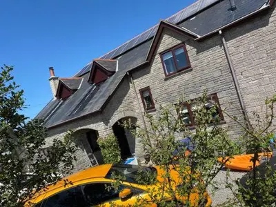a yellow bus parked in front of a house at Meadowview Cottage, St Ives View in Camborne