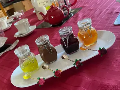 a plate with three jars of honey on a table at Meadowview Cottage, St Ives View in Camborne