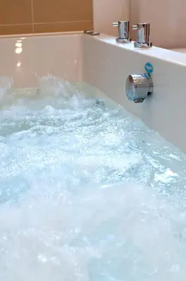 a bath tub filled with lots of water at Fistral hot tub house for 8 on Retallack Resort in Newquay