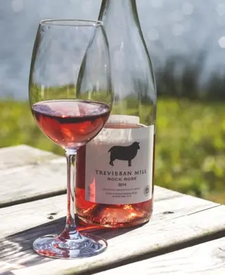 a glass of wine sitting next to a bottle of wine at Fistral hot tub house for 8 on Retallack Resort in Newquay