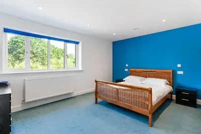 a bedroom with a bed and a blue wall at Shackled-Am-Not - Luxury home sleeps 8 with hot tub and games room North Cornwall in Camelford