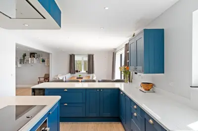 a kitchen with blue cabinets and white counter tops at Shackled-Am-Not - Luxury home sleeps 8 with hot tub and games room North Cornwall in Camelford