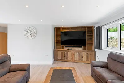 a living room with two couches and a flat screen tv at Shackled-Am-Not - Luxury home sleeps 8 with hot tub and games room North Cornwall in Camelford