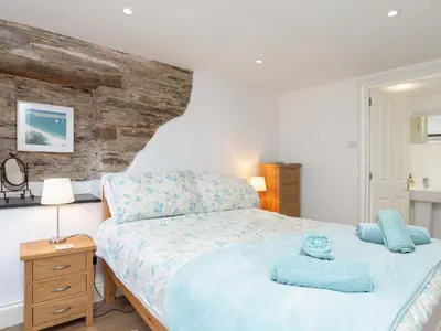 a bedroom with a bed with blue towels on it at Dayan Cottage in Fowey