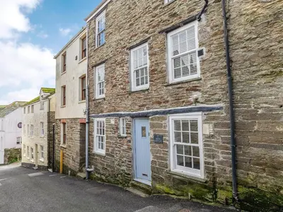 an old brick building with a white door at Dayan Cottage in Fowey