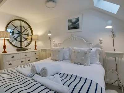 a bedroom with a white bed with towels on it at The Salt Loft in Fowey