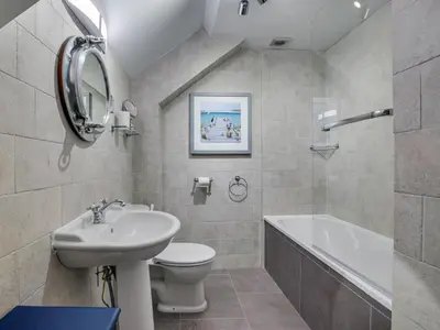a bathroom with a sink and a toilet and a bath tub at The Salt Loft in Fowey