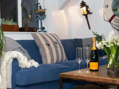 a blue couch with wine glasses on a table at The Salt Loft in Fowey